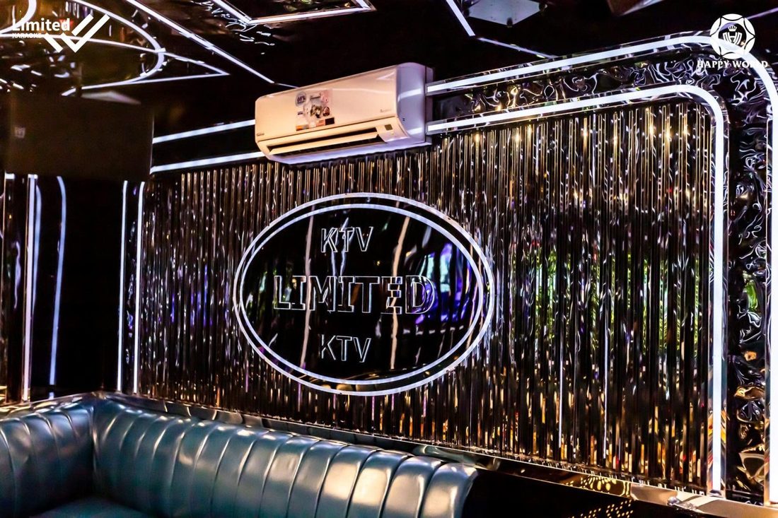 363 KTV 银色流苏光墙上的 KTV LIMITED 圆形标志与墨绿皮质卡座