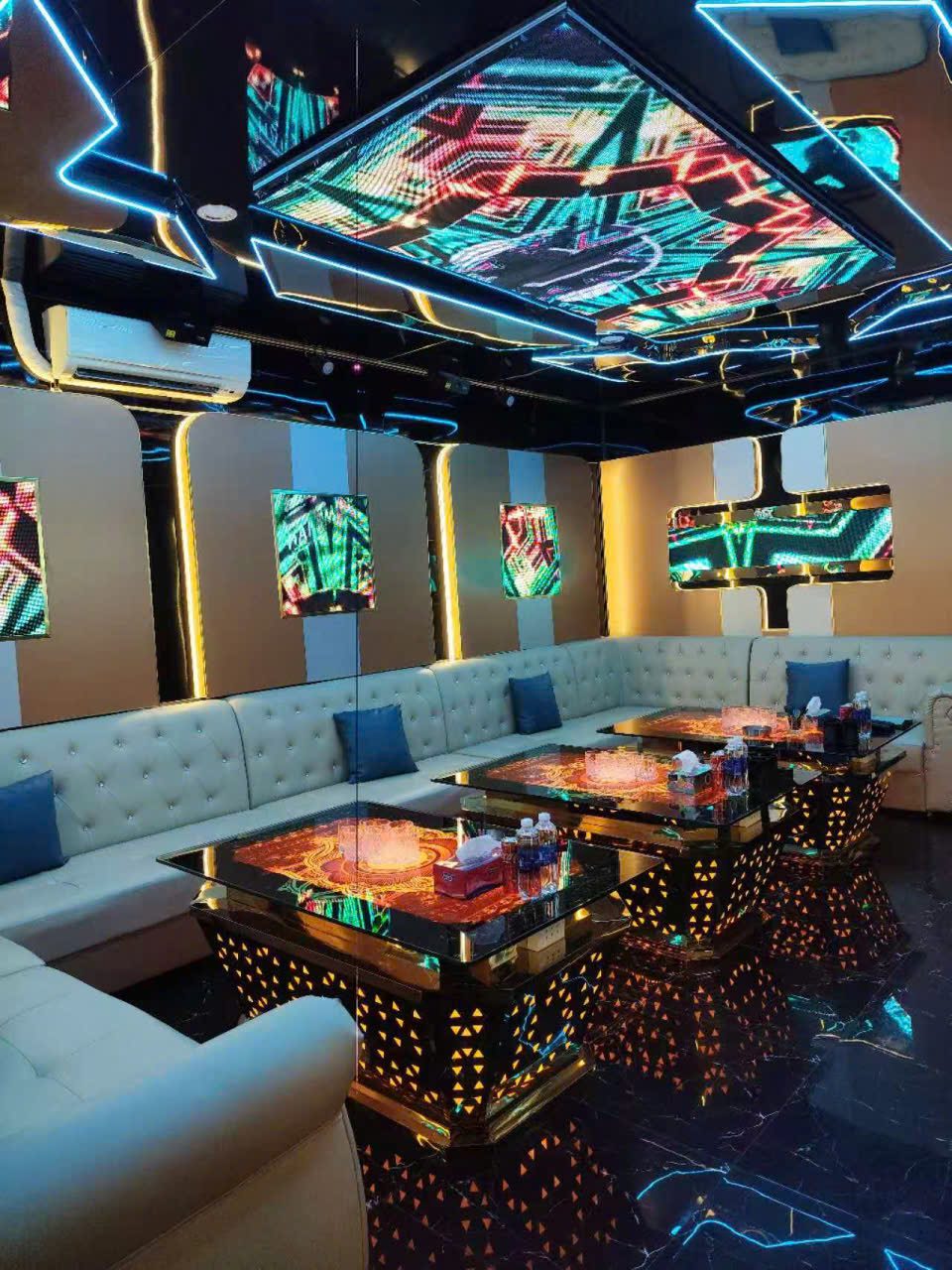 41 LUXURY KTV 胡志明第五郡包厢内景：LED 拼贴天花、象牙白菱格皮卡座与三张金脚发光长台