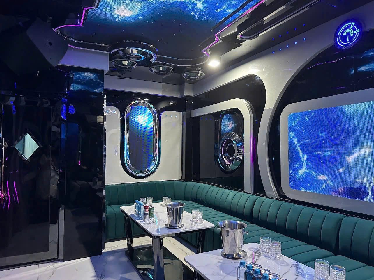 ATLANTIS KTV 胡志明第一郡潜艇舱主题包厢，舷窗屏幕放深海画面，深绿丝绒卡座配白色大理石桌