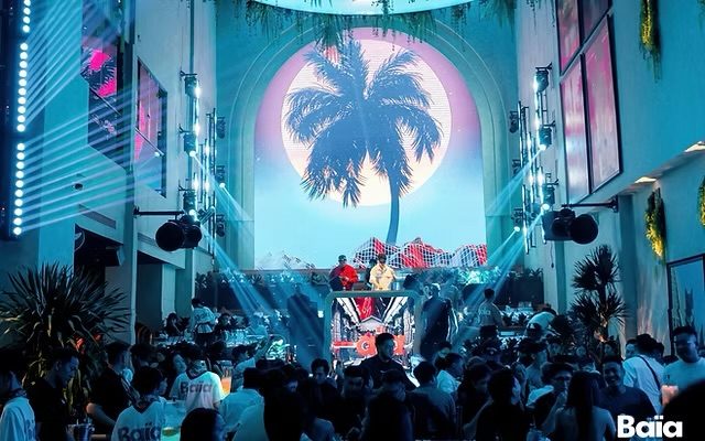 BAIA SAIGON 拱门巨幕 LED 放着棕榈树与满月，DJ 岛前站满人群