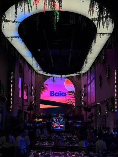 BAIA SAIGON 天花板中央的椭圆灯碗吊环，边缘垂满藤蔓绿植