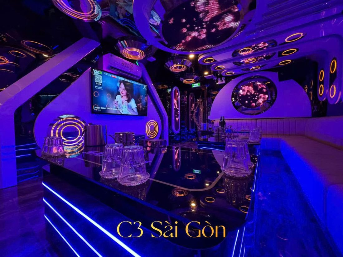 C3 SÀI GÒN KTV 小房：黑镜玻璃桌、灯带底座与金色光圈装饰