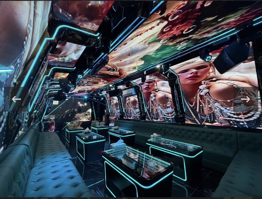 DRAGON PALACE KTV 长条形包厢,墙面与天花全是 LED 屏放珠宝人像画面,青绿灯带勾边,墨绿绒面钮扣长沙发