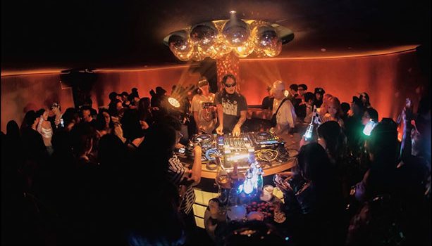 FETTI BAR 的 DJ 站在店正中的岛台里打碟，头顶一簇迪斯科球，客人从四面围住