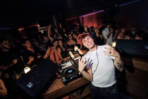 FETTI BAR 的 DJ 在 CDJ 打碟机前，客人贴着台边举手