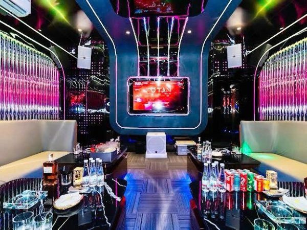 豪門 KTV 对称长厅 粉紫水晶灯柱墙与中央大屏