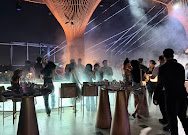 KÉN SKYBAR 深夜时段：干冰烟雾铺满地面，白色光束打向伞状顶盖，全场人影攒动