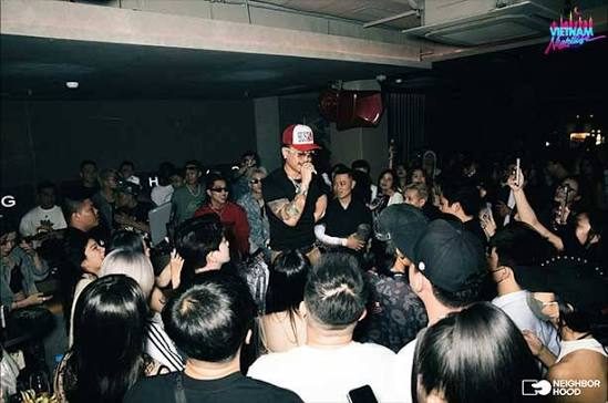 NEIGHBORHOOD BAR 现场：MC 站在人群中央表演，四周全是举手机拍摄的客人