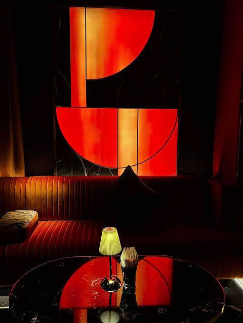 PAPI BAR 店内红橙半圆抽象画墙,画前是一整条丝绒长卡座与黑色大理石圆桌,桌上两盏小褶皱台灯