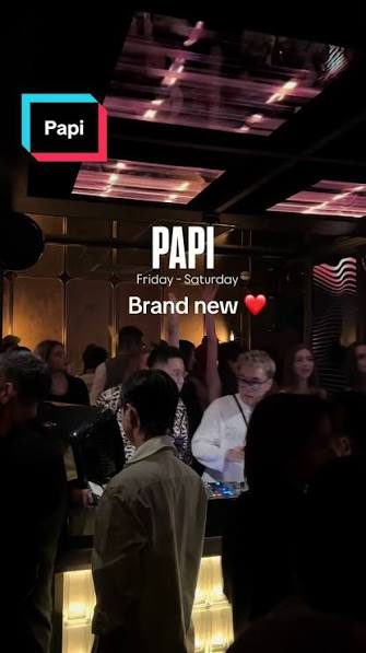 PAPI BAR 周末现场人群,天花板整片粉红 LED 条灯,场内站满举手的客人