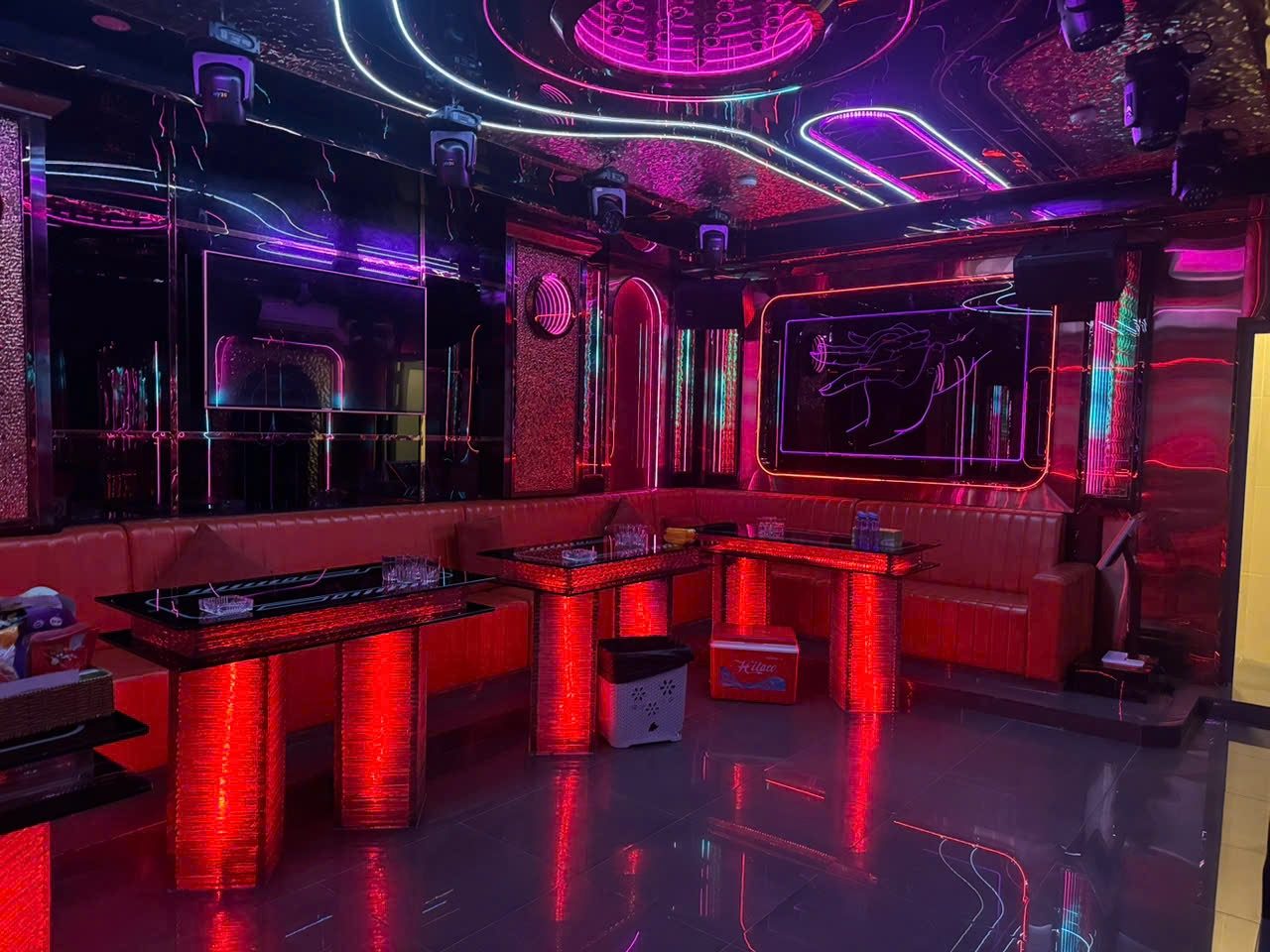 PATTAYA KTV 胡志明中山区包厢，红紫霓虹镜面天花配红色皮革卡座与发光茶几