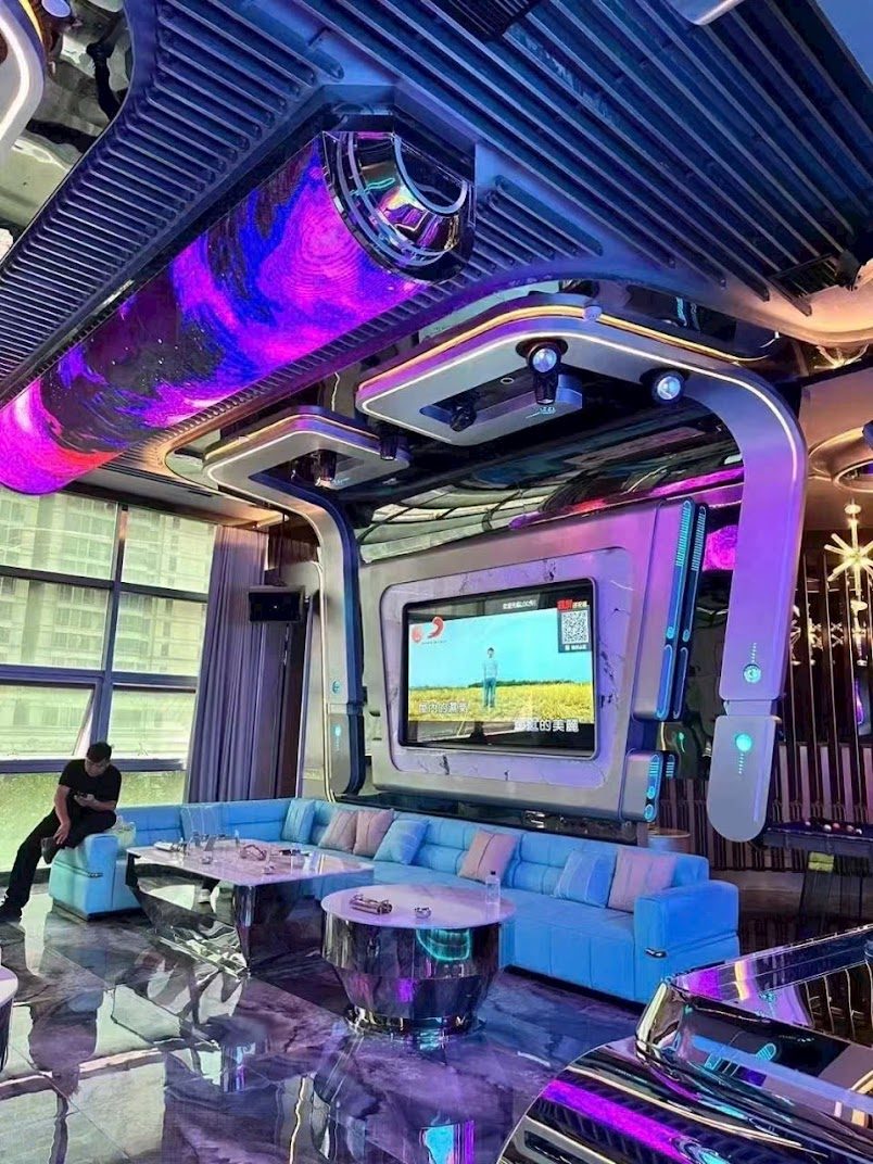河内 ROYAL KTV 落地窗日光包厢，弧形 LED 桶屏与天蓝色皮沙发