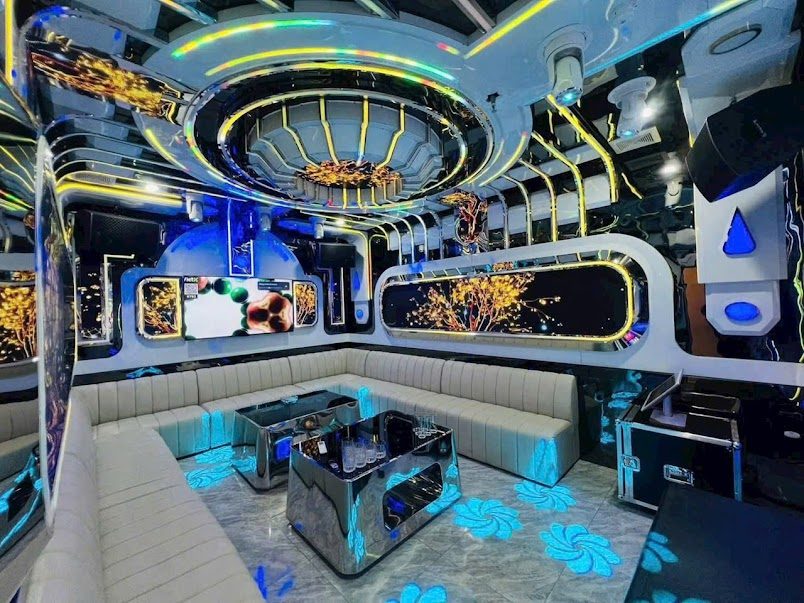 河内 ROYAL KTV 金蓝色太空舱主题包厢，椭圆镜面吊顶与米白皮革长卡座