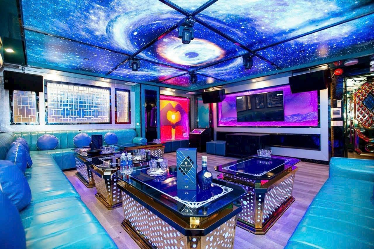 SAIGON STAR KTV 星空主力包厢：整片星云印花天花板、湖蓝皮质长卡座与金座玻璃长台